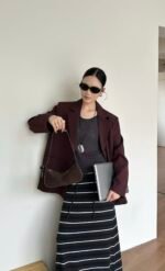 Nodo underarm bag model shot in dark red sweater